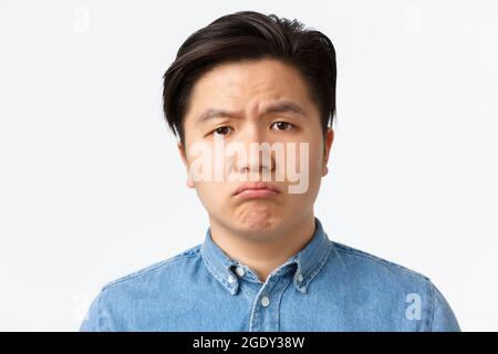Kieferorthopädie, Zahnpflege und Stomatologie Konzept. Close-up von düster und traurig niedlich asiatische Kerl schmollend, Blick aufgeregt auf Kamera, Gefühl einsam oder Stockfoto
