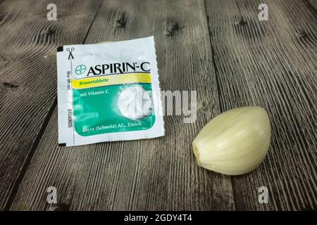 Eine Tüte Aspirin mit Vitamin C und einem Kopf geschälten Knoblauchs Stockfoto