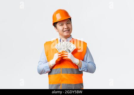 Baugewerbe und Industriearbeiter Konzept. Glücklich zufrieden Asian Baumeister, Bauleiter in reflektierender Kleidung und Helm lächelnd zufrieden Stockfoto