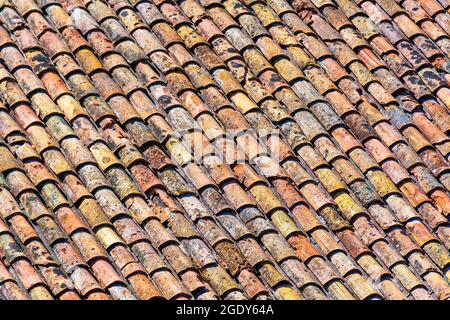 Altes Dach aus traditionellen römischen Terrakotta-Fliesen auf einem alten Haus im Süden Frankreichs. Nahaufnahme für Textur Stockfoto