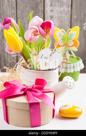 Ein Haufen magenta-rosa gelber Tulpen auf rustikalem Holzhintergrund, pastellfarbene Blumentöpfe, Happy Mothers Day oder Valentinskarte Stockfoto