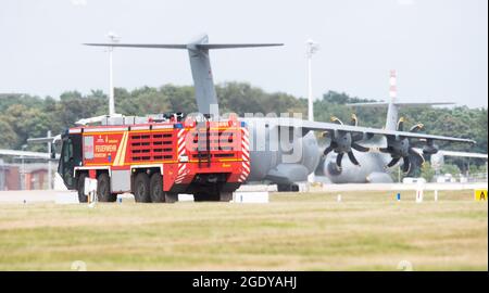 Wunstorf, Deutschland. August 2021. Ein Airbus A400M befördert Flugzeuge der deutschen Luftwaffe über die Start- und Landebahn neben einem Fahrzeug der Flughafenfeuerwehr auf dem Luftwaffenstützpunkt Wunstorf in der Region Hannover. Angesichts des raschen Vormarsch der Taliban in Afghanistan will die Bundeswehr damit beginnen, deutsche Bürger und lokale afghanische Truppen aus Kabul zu evakuieren. Quelle: Julian Stratenschulte/dpa/Alamy Live News Stockfoto