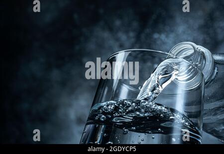 Gießt Wasser auf schwarzem Hintergrund mit Kopierraum Stockfoto