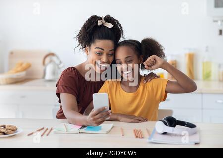 Emotionale Mutter und Tochter, die zusammen Selfie machen Stockfoto