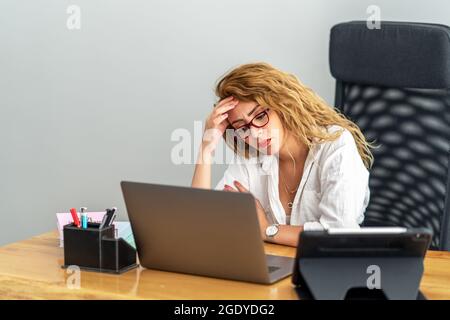 Die junge Frau arbeitet hart in ihrem Büro und beschäftigt sich mit Prblemen, mit moderner Ausrüstung. Hochwertige Fotos Stockfoto