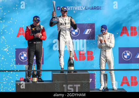 Berlin, Deutschland. August 2021. Motorsport: Formel-E-Weltmeisterschaft, ePrix 2021, Rennen auf dem ehemaligen Flughafen Tempelhof. Der Vizemeister Oliver Rowland (l-r) vom Team Nissan e.Dams, der Sieger Norman NATO vom Team ROKIT Venturi Racing und der drittplatzierte Stoffel Vandoorne vom Mercedes-Benz EQ Formula E Team stehen bei der Preisverleihung zusammen. Quelle: Andreas Gora/dpa/Alamy Live News Stockfoto