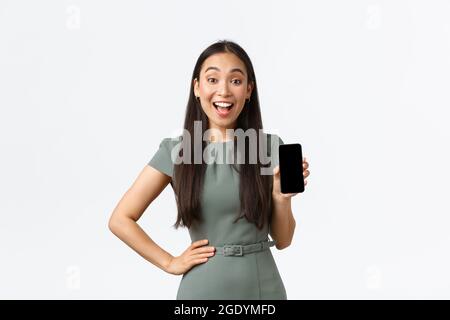Kleinunternehmer, Frauen Unternehmer Konzept. Aufgeregt asiatische Geschäftsfrau machen Ankündigung, zeigt Smartphone-Bildschirm-Anwendung mit erstaunt Stockfoto