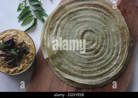 Eiweißreicher Moong-Bohne-Crepe, lokal als Pesarattu bekannt. Es sieht aus wie Dosa, aber nicht mit fermentiertem Teig. Ausgeklappt serviert mit dem Rundschreiben Stockfoto