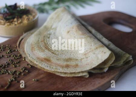 Eiweißreicher Moong-Bohne-Crepe, lokal als Pesarattu bekannt. Es sieht aus wie Dosa, aber nicht mit fermentiertem Teig. Serviert zusammen mit Kokosnuss chu gefaltet Stockfoto