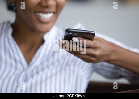 Nahaufnahme einer ethnischen Frau, die eine Sprachnachricht auf der Zelle aufzeichnet Stockfoto
