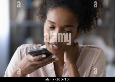 Nahaufnahme einer ethnischen Frau, die eine Audiobotschaft auf eine Zelle aufzeichnet Stockfoto