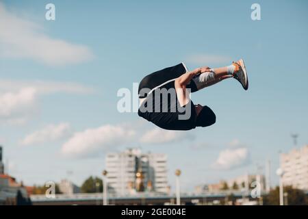 Junger sportlicher Kerl, der Parkour an der Stadtstraße macht Stockfoto