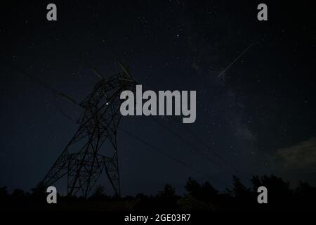 Powerline-Pylon gegen die sternenklare Sommernacht Stockfoto