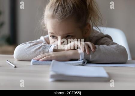 Unglückliches kleines Mädchen fühlt sich faul beim Studieren zu Hause Stockfoto