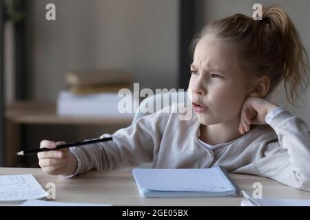 Unglückliches kleines Mädchen fühlt sich unmotiviert, zu Hause zu studieren Stockfoto