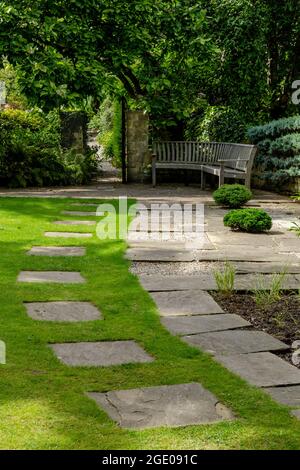 Ein Weg über einen Rasen, der zu einem offenen Tor in Yorkshire, England, führt. Stockfoto