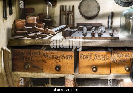 Eine Werkbank mit alten Gartenwerkzeugen in einem Topfschuppen im York Gate Garden, Leeds. Stockfoto