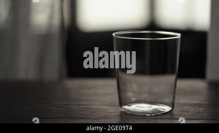 Leeres Glas auf Eichentisch, 120fps Stockfoto