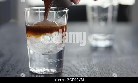 Espresso Tonic im Becher mit Eiskugel, breites Foto Stockfoto