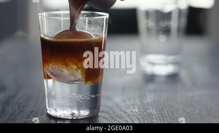 Espresso Tonic im Becher mit Eiskugel, breites Foto Stockfoto