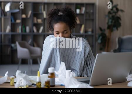 Ungesunde ethnische Frauen fühlen sich krank, wenn sie am Computer arbeiten Stockfoto