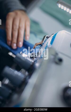 Junge schöne Näherin näht auf Nähmaschine in der Fabrik. Stockfoto