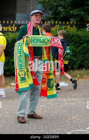 Norwich, Großbritannien. August 2021. Ein Schal-Verkäufer vor dem Premier League-Spiel zwischen Norwich City und Liverpool in der Carrow Road am 14. August 2021 in Norwich, England. (Foto von Mick Kearns/phcimages.com) Credit: PHC Images/Alamy Live News Stockfoto