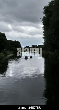 Vier nicht identifizierbare Personen, die Kajaks in einem Kanal in Exeter, Devon, England, Großbritannien, benutzen. Stockfoto