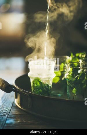 Frischer marokkanischer Minztee mit Kräuterblättern in Gläsern Stockfoto