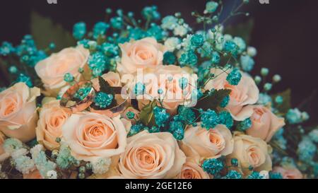 Zartes romantisches Brautstrauß aus Pfirsichrosen mit Eheringen Stockfoto