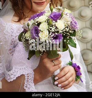 Zartes Bouquet von weißen und violetten Rosen in den Händen der Braut close-up Stockfoto