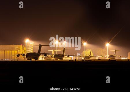 Wunstorf, Deutschland. August 2021. Air Force Transportflugzeuge des Typs Airbus A400M und andere stehen heute Abend hinter einem Zaun auf dem Luftwaffenstützpunkt Wunstorf in der Region Hannover. Angesichts des raschen Vormarsch der Taliban in Afghanistan plant die Bundeswehr, am Montag (16.08.2021) mit der Evakuierung deutscher Staatsbürger und lokaler afghanischer Truppen aus Kabul zu beginnen. Quelle: Moritz Frankenberg/dpa/Alamy Live News Stockfoto