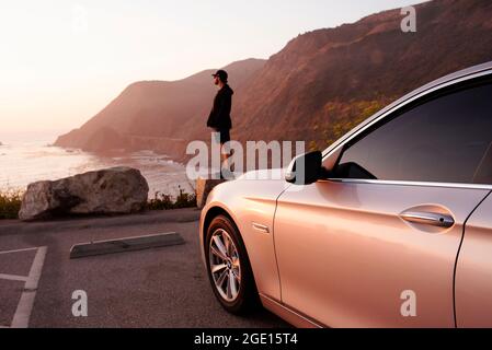 Mann, der das Meer bei Sonnenuntergang an einem Küstenaussicht entlang des Highway 1 beobachtet. Big Sur, Kalifornien, USA. September 2019 Stockfoto
