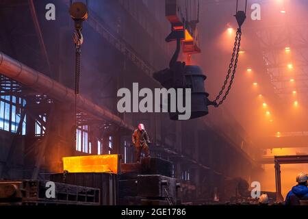 Große Schöpfkelle auf dem Kran vor dem Schmelzen in der Gießerei. Schmelzen von Teilen aus Gusseisen mit mehreren Tonnen. Metallurgische Anlage oder Stahlwerk. Stockfoto