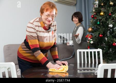 Reife Mutter und erwachsene Tochter bereiten, um Platz für das Neue Jahr Stockfoto