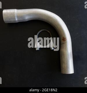 Ein Universal-Auspuffrohr und eine Klemme auf schwarzem Hintergrund Stockfoto