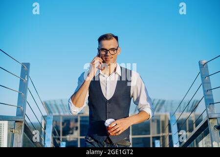 Geschäftsmann, der auf die Terrasse eines modernen Büros geht. Stockfoto