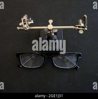 Brille vor einer kleinen Klemmvorrichtung Stockfoto