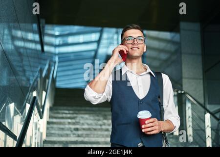 Selbstbewusster junger Unternehmer im Gespräch auf dem Smartphone. Stockfoto