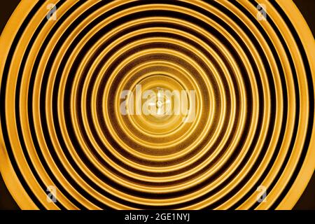 Radiale Linienform der Deckenleuchte von unten mit einer Glühlampe in der Mitte und einer schwarzen runden Linie um die Lampe herum Stockfoto