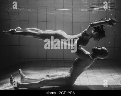 Unterwasserporträt des atletischen, sportlichen Tanzes und Yoga-Asanas-Paare (Mann und Frau) unter Wasser im Schwimmbad Stockfoto