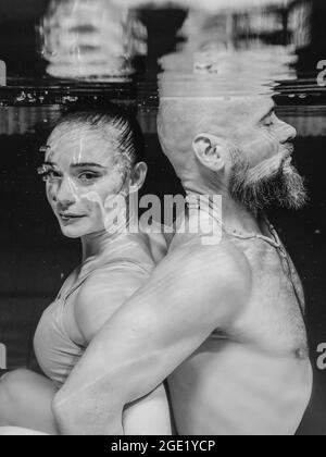 Unterwasserporträt des atletischen, sportlichen Tanzes und Yoga-Asanas-Paare (Mann und Frau) unter Wasser im Schwimmbad Stockfoto