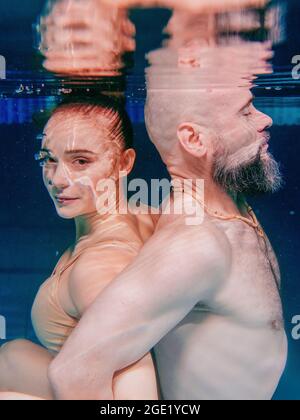 Unterwasserporträt des atletischen, sportlichen Tanzes und Yoga-Asanas-Paare (Mann und Frau) unter Wasser im Schwimmbad Stockfoto