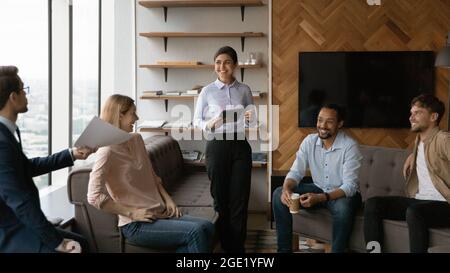 Fröhliche, erfolgreiche Geschäftsleute versammelten sich im Bürozimmer Stockfoto