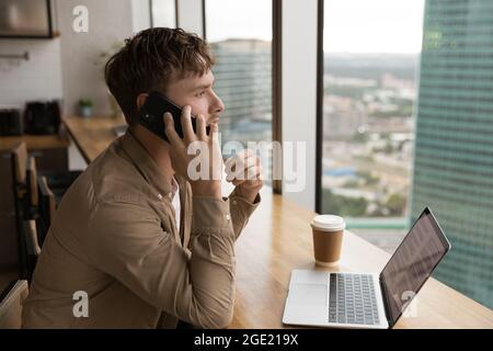 Der Geschäftsmann sitzt im modernen Büro und telefoniert Stockfoto
