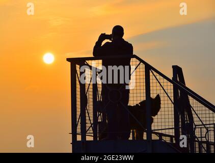 16/08/2021 Gravesend UK der Morgen dämmert über der geschäftigen Themse in der Nähe von Gravesend in Kent. Ein Hundespaziergang am frühen Morgen machte gegen die Morgendämmerung eine Silhouette Stockfoto