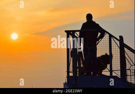 16/08/2021 Gravesend UK der Morgen dämmert über der geschäftigen Themse in der Nähe von Gravesend in Kent. Ein Hundespaziergang am frühen Morgen machte gegen die Morgendämmerung eine Silhouette Stockfoto