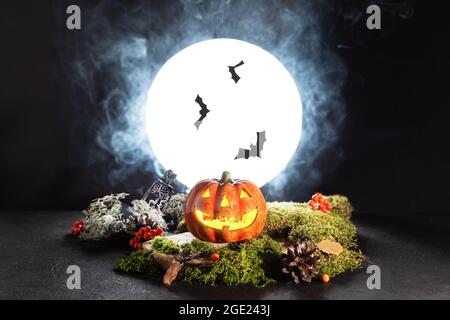 Halloween Kürbis Jack O’ Laternen glühen in gruseliger Nacht bei Vollmondlicht. Halloween Grußkarte. Halloween beängstigendes Stillleben. Stockfoto