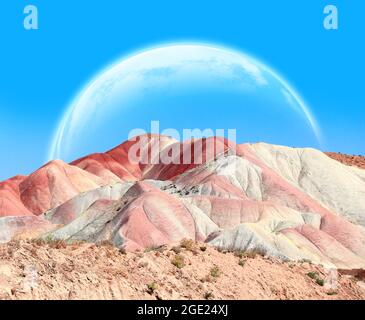 Fantastische Landschaft mit bunten Bergen und Planeten in blauem Himmel. 3d-Rendering. Elemente dieses Bildes, die von der NASA eingerichtet wurden Stockfoto