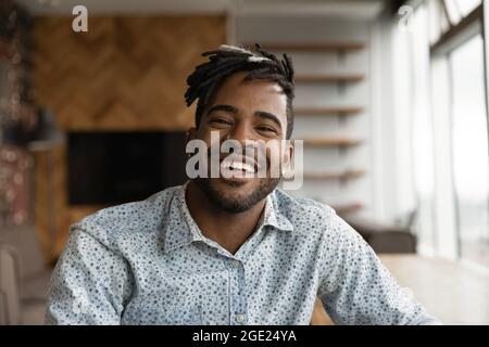 Afrikanischer stylischer Hipster-Kerl mit Dreadlocks lächeln Blick auf die Kamera Stockfoto